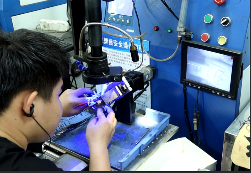 Operator using laser welding machine for precise metal eyewear frame soldering